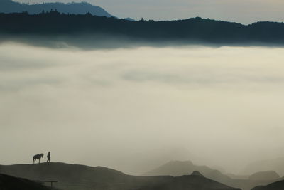 Scenic view of silhouette mountains against sky at dusk