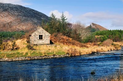 Stone house in wilderness, landscape with river and mountains, derryclare, connemara, ireland