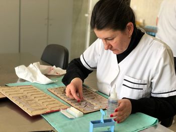 Female scientist examining microscope slide at laboratory