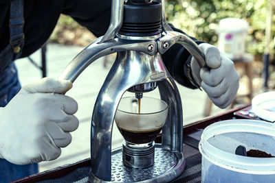 Close-up of hand holding glass bottle on table
