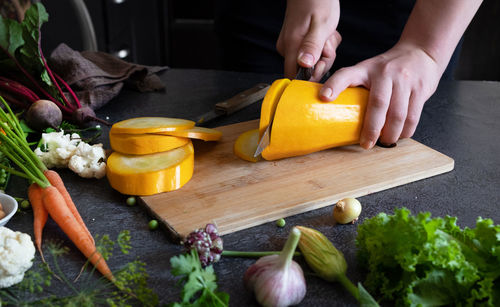Cropped hand of man preparing food on table