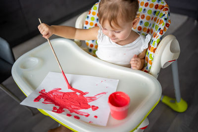 High angle view of cute baby boy holding bowl