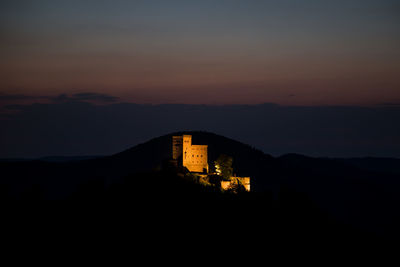 Silhouette buildings against sky at sunset