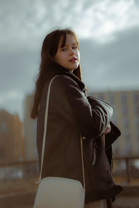 Side view of woman in leather jacket looking in the camera