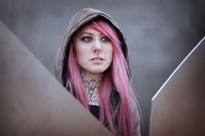 Young woman in pink hair looking away