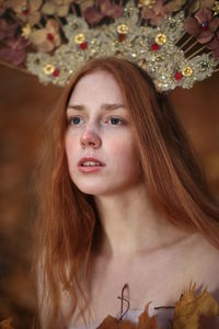 Thoughtful young woman with redhead wearing flowers on hair