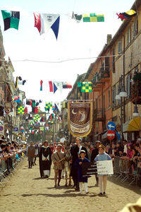 People at town square against sky in city