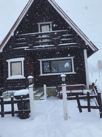 Snow covered house against building