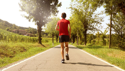 Rear view of man running on road