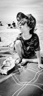 Girl sitting on shore at beach