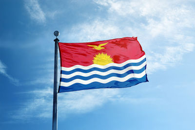 Low angle view of flag against blue sky