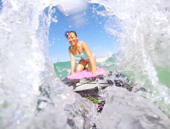 Smiling woman surfing in sea 