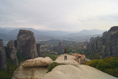 Rear view of man looking at mountains against sky