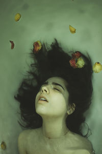 Close-up portrait of young woman swimming in water