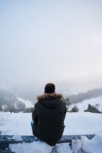 Young man is looking at the horizon on a snowy day