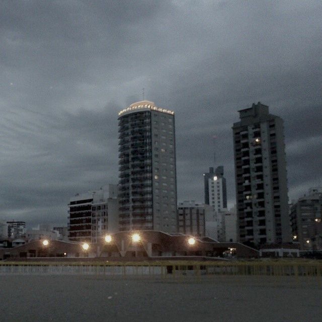 building exterior, architecture, built structure, city, sky, illuminated, skyscraper, cloud - sky, night, tall - high, modern, office building, tower, cityscape, building, cloudy, urban skyline, dusk, residential building, weather