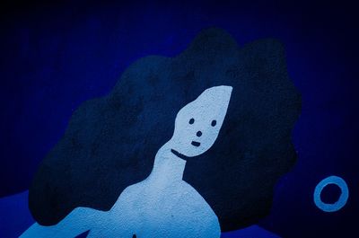 Close-up of illuminated light painting against blue wall