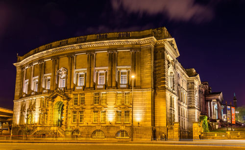 Low angle view of illuminated building against sky at night