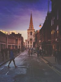 People walking on street in city against sky