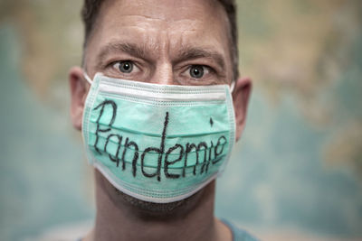 Caucasian man with mouth guard in front of whole world map, pandemic