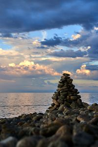 Stack of rocks on shore during sunset
