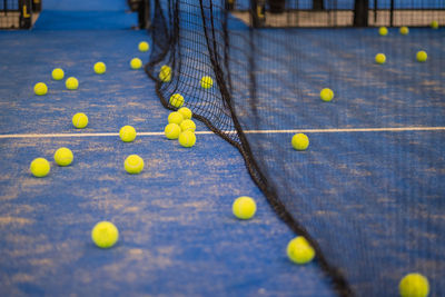 Tennis ball on the floor after a match - padel balls - yellow tennis balls in court on blue turf