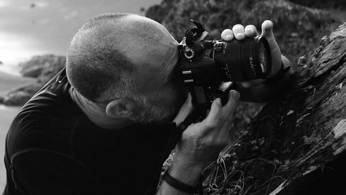 Close-up of man photographing through camera