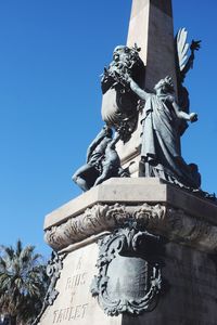 Low angle view of statue against clear blue sky
