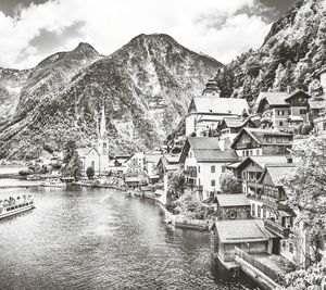 Houses by river against sky