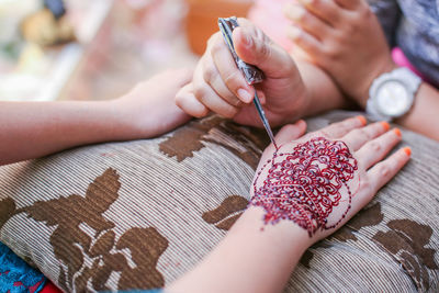 High angle view of woman holding hands on table