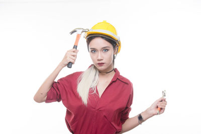 Portrait of woman with arms raised standing against white background