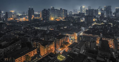 Aerial view of illuminated cityscape against sky at night