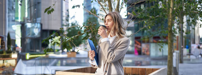 Portrait of young woman standing in city