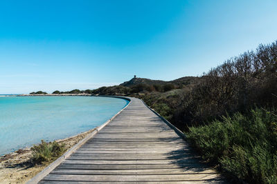 Wooden walkway on porto giunco beach in villasimius