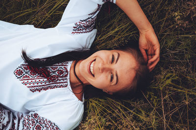 Photo of a smiling young woman in ethnic ukrainian shirt, enjoying the beautiful weekend getaway