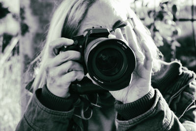 Close-up of woman photographing while standing at field