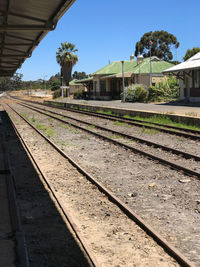 Railroad tracks by trees against sky