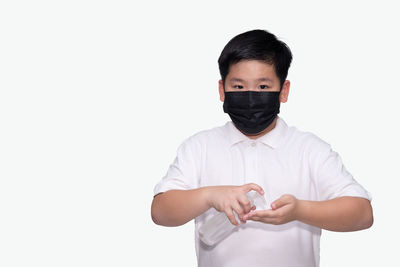 Portrait of boy standing against white background