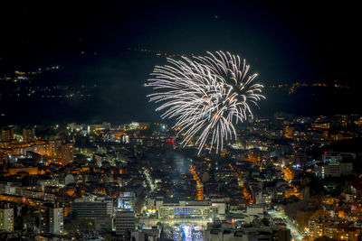 Fireworks above city in the winter nights white