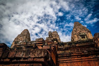 Low angle view of historic temple against cloudy sky