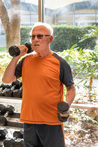 Portrait of senior man lifting dumbbells in gym