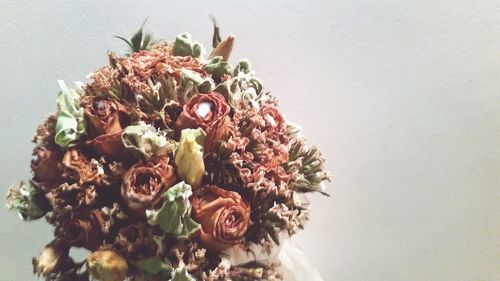 Close-up of wilted flower bouquet against wall