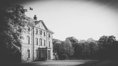 Old building by trees against sky