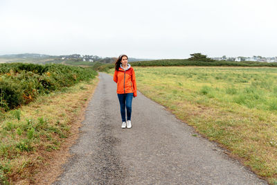 Full length of teenage girl on road against sky