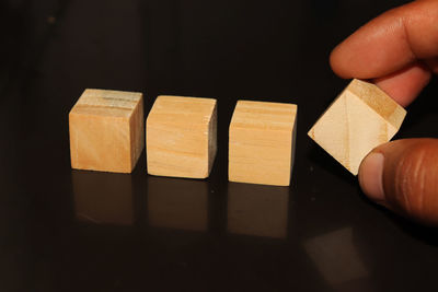 Close-up of hand holding table against black background