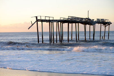 Silhouette lifeguard hut on beach against clear sky