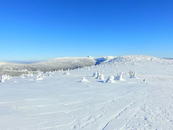 Scenic view of snowcapped mountains against clear blue sky