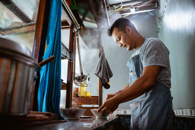 Midsection of man preparing food in kitchen