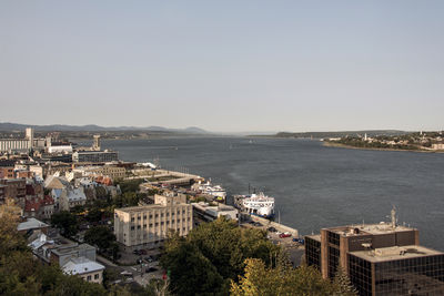 High angle view of buildings by sea against clear sky