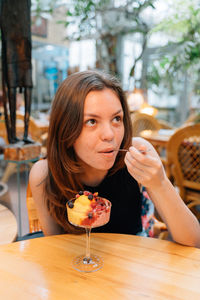 Portrait of young woman sitting on table